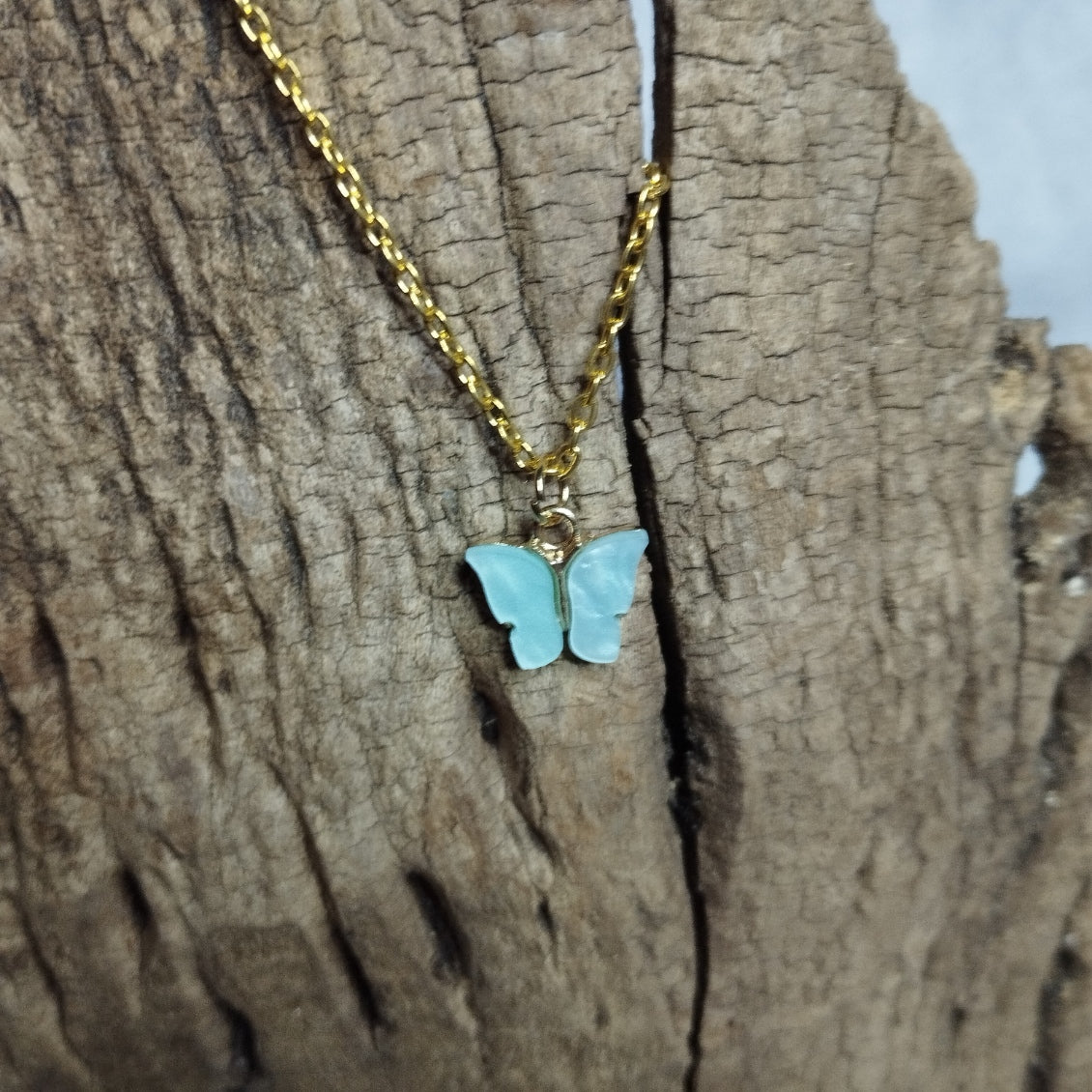 Collier papillon bleu ciel sur chaîne dorée