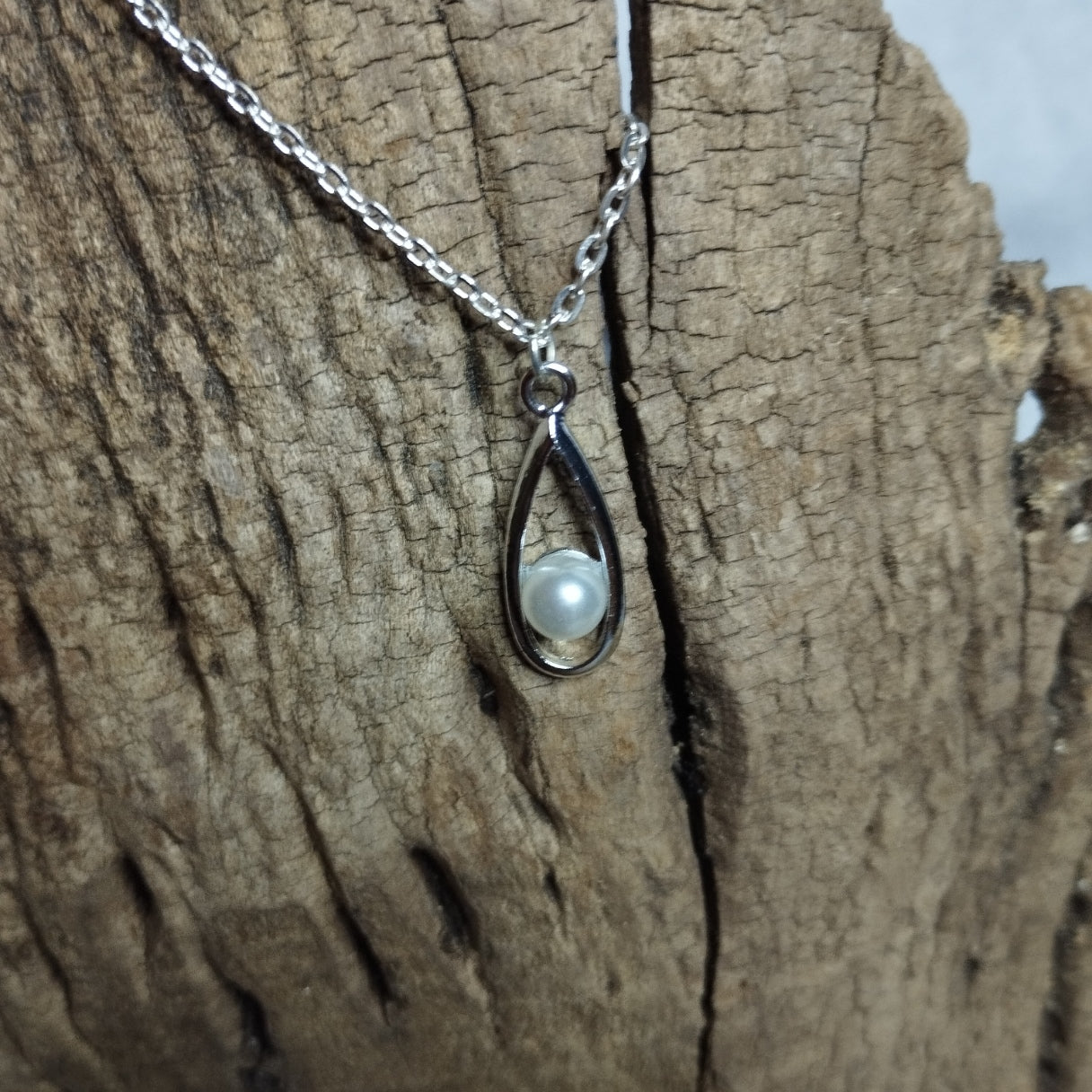 Collier pendentif goutte argentée avec perle nacrée enchâssée sur chaîne en acier