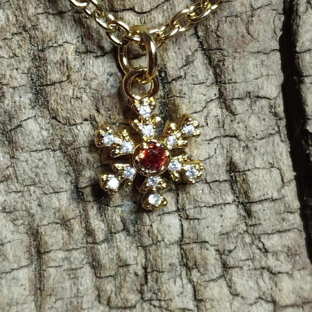 Collier flocon de neige doré strass gros plan cristal rouge