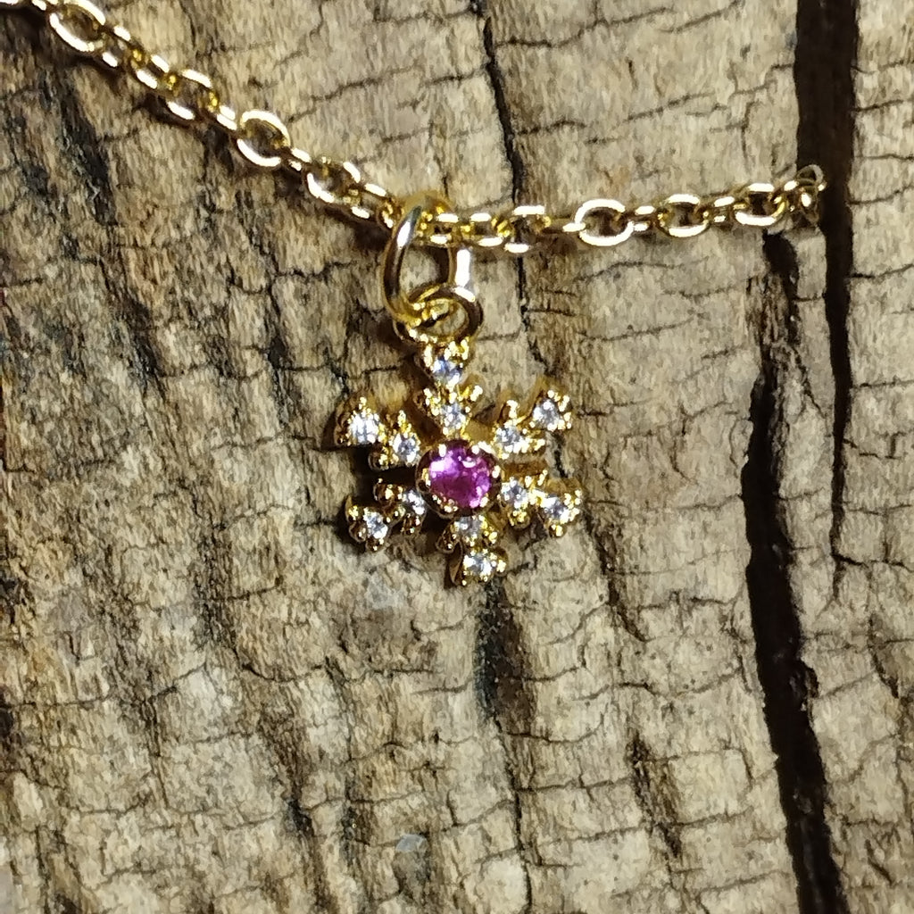 Collier flocon de neige doré strass gros plan cristal rose fuchsia