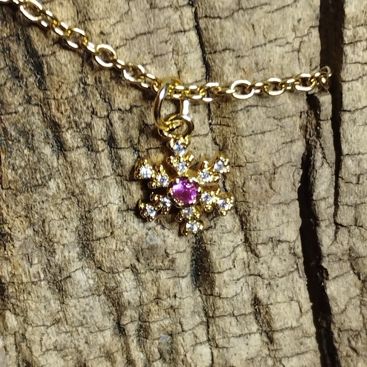 Collier flocon de neige doré strass gros plan cristal rose fuchsia