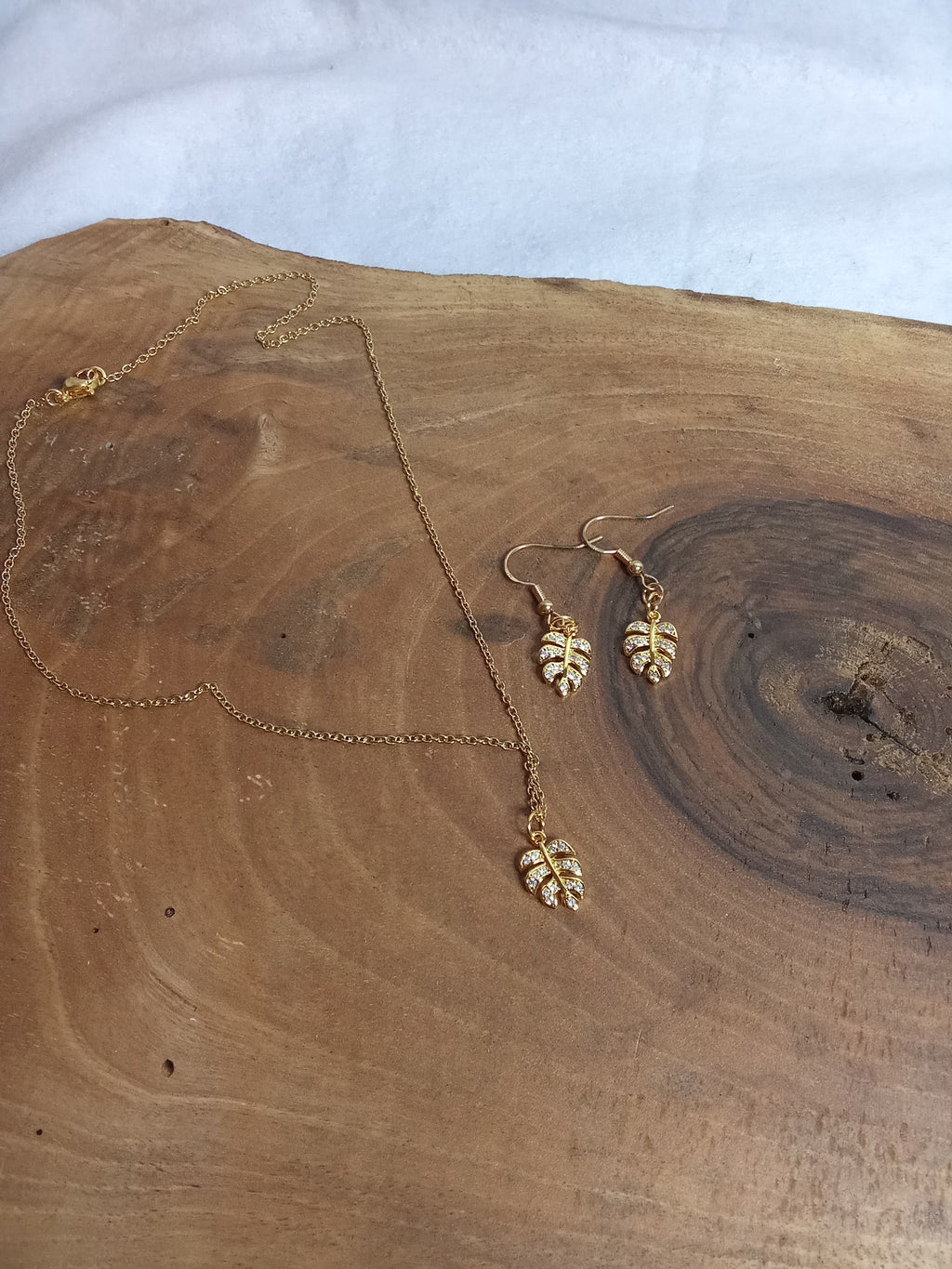 Vue d’ensemble parure Monstera strass sur chaîne dorée en acier inoxydable