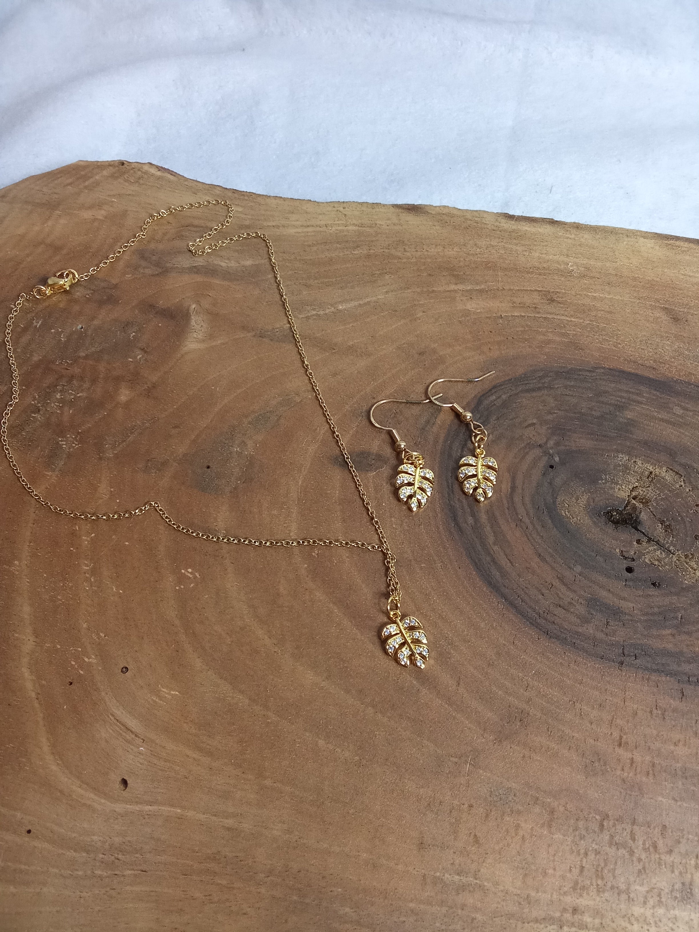 Vue d’ensemble parure Monstera strass sur chaîne dorée en acier inoxydable
