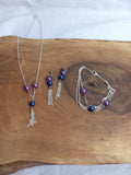 Parure complète violet et bleu avec collier, bracelet et boucles d’oreilles pompons