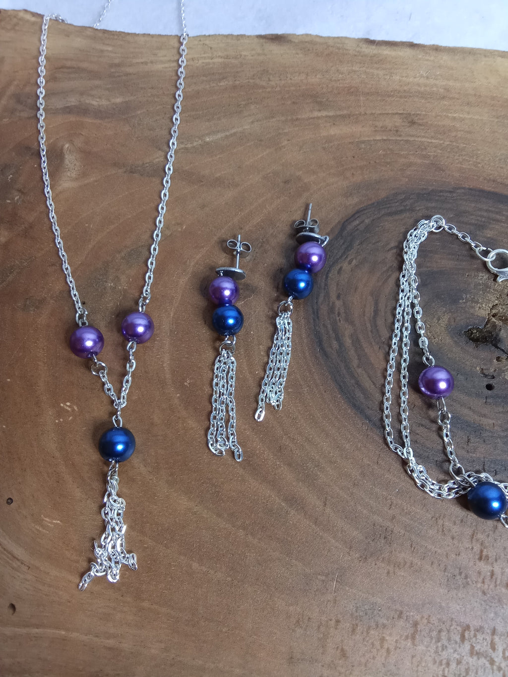 Gros plan parure perles violet et bleu avec pompons de chaînettes argentées